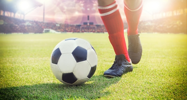 Foto jugador de fútbol o fútbol de pie con la bola en el campo para patear el balón de fútbol