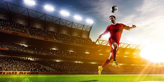 Jugador de fútbol pateando la pelota frente a un estadio