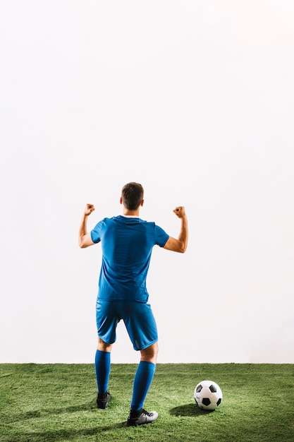 Foto jugador de fútbol sin rostro que se regocija con la victoria