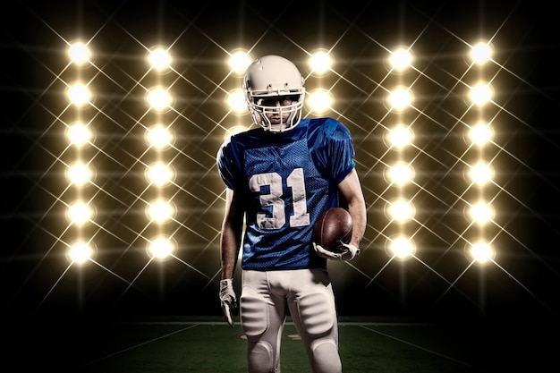 Foto jugador de fútbol con un uniforme azul frente a las luces