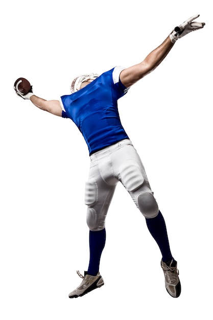 Jugador de fútbol con un uniforme azul haciendo una captura en una pared blanca