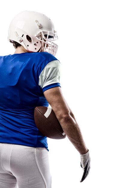 Jugador de fútbol con un uniforme azul sobre una pared blanca