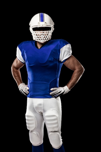 Jugador de fútbol con un uniforme azul sobre una pared negra