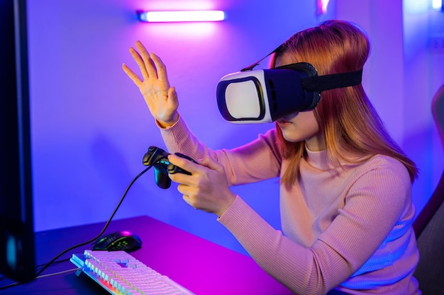 Jugador con gafas de auriculares VR explorando el metaverso juega videojuegos en línea tocando algo en el aire y sosteniendo el joystick Mujer emocionada jugando viendo video simulación de vida en casa