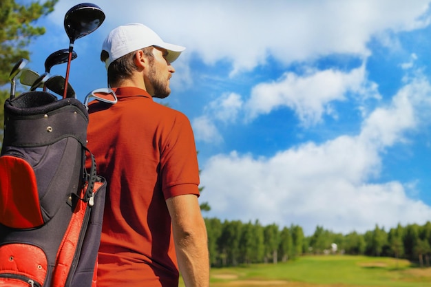Jugador de golf caminando y llevando bolsa en curso durante el juego de golf de verano