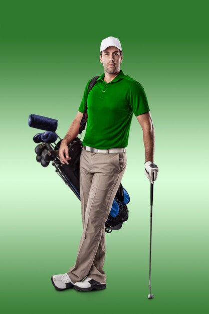 Foto jugador de golf con una camisa verde, de pie con una bolsa de palos de golf en la espalda, sobre un fondo verde.