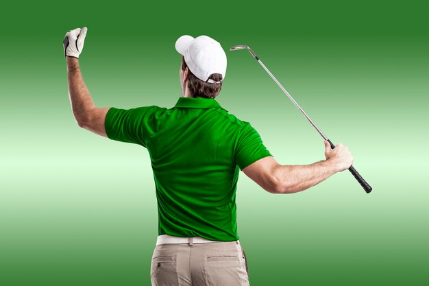 Foto jugador de golf en una camiseta verde celebrando, sobre un fondo verde.