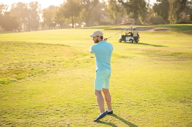 Jugador de golf masculino en un campo soleado profesional con hobby de hierba verde