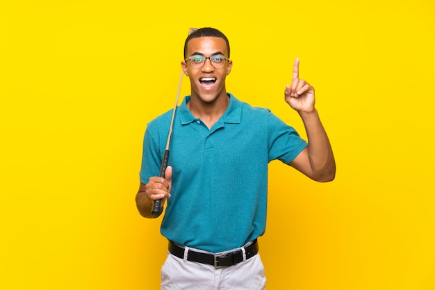 Jugador de golfista afroamericano con la intención de darse cuenta de la solución mientras levanta un dedo
