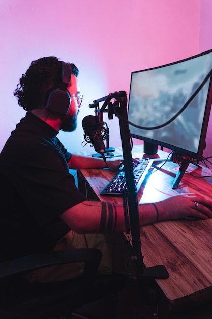 Jugador hispano profesional con auriculares y micrófono jugando un juego en línea