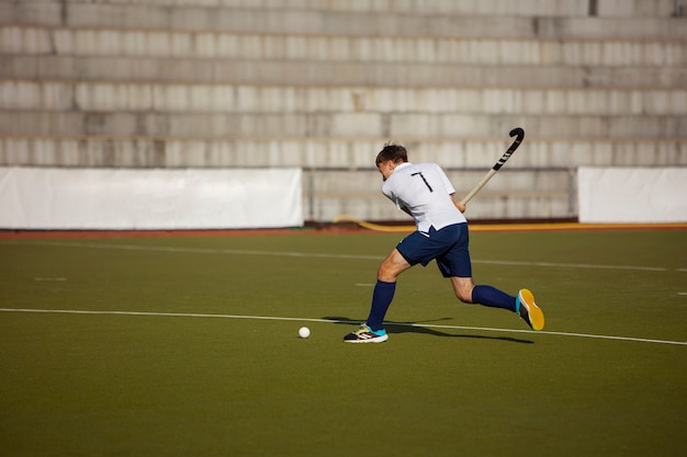 Foto jugador de hockey sobre césped entrenando y practicando el deporte sobre hierba