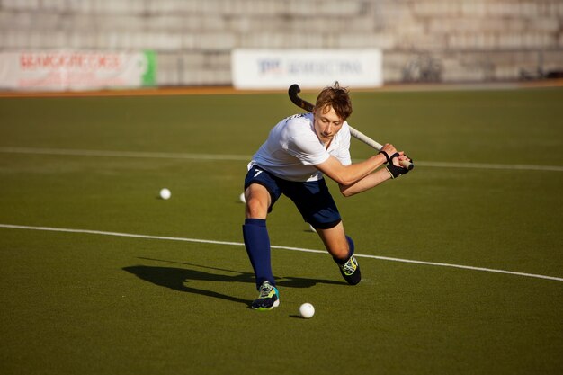 Jugador de hockey sobre césped entrenando y practicando el deporte sobre hierba