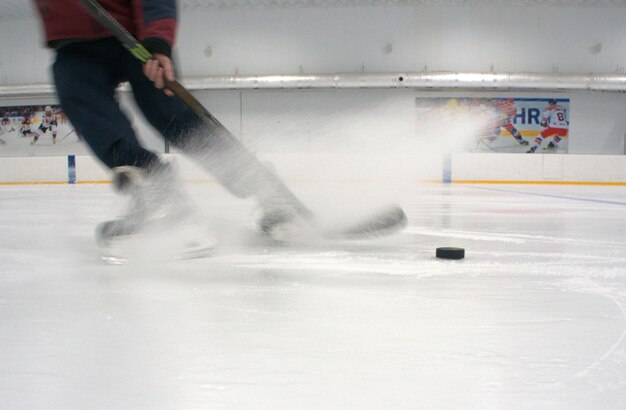 Jugador de hockey sobre hielo en acción pateando con palo