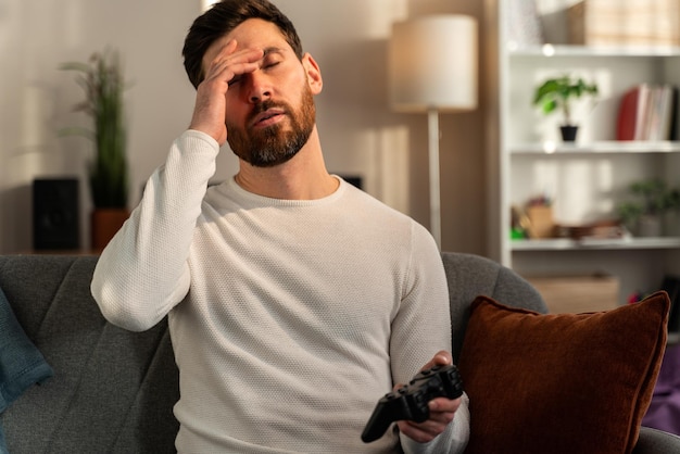 El jugador con joystick pierde en el juego. Perdió la oportunidad de convertirse en campeón en un torneo. Joven jugando videojuegos en línea en casa