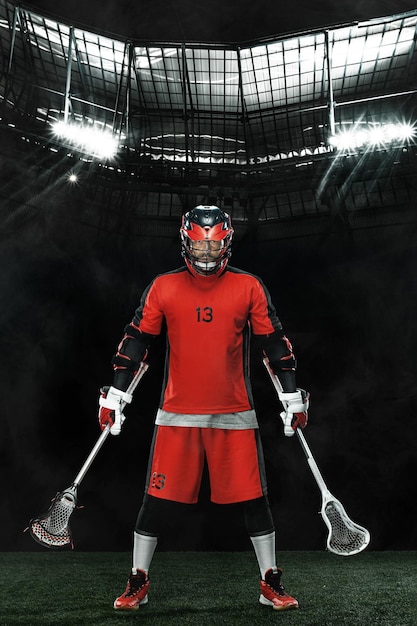 Jugador de lacrosse atleta deportista con casco rojo en fondo oscuro papel pintado de deporte y motivación