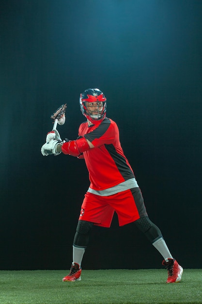 Jugador de lacrosse atleta deportista en casco rojo sobre fondo oscuro deporte y fondo de pantalla de motivación