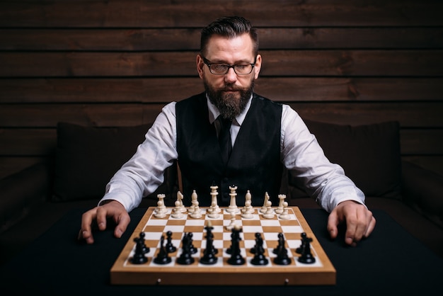 Jugador masculino contra tablero de ajedrez con juego de piezas