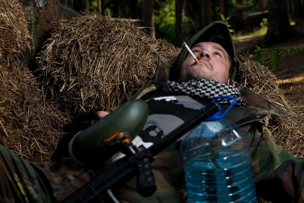 Jugador de paintball descansando y fumando un puro