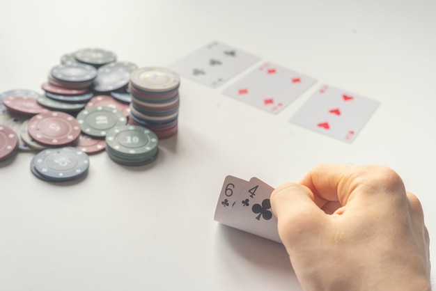 Un jugador de póquer de cerca sosteniendo una carta en la mesa gana o pierde un concepto simple
