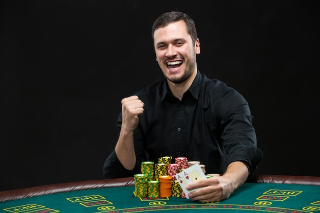 Jugador de póquer feliz ganando y sosteniendo un par de ases