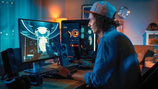 Jugador profesional jugando a videojuegos en línea de disparos en primera persona en su potente computadora personal con coloridas luces de neón Young Man is Wearing a Cap Sala de estar iluminada con lámparas cálidas noche