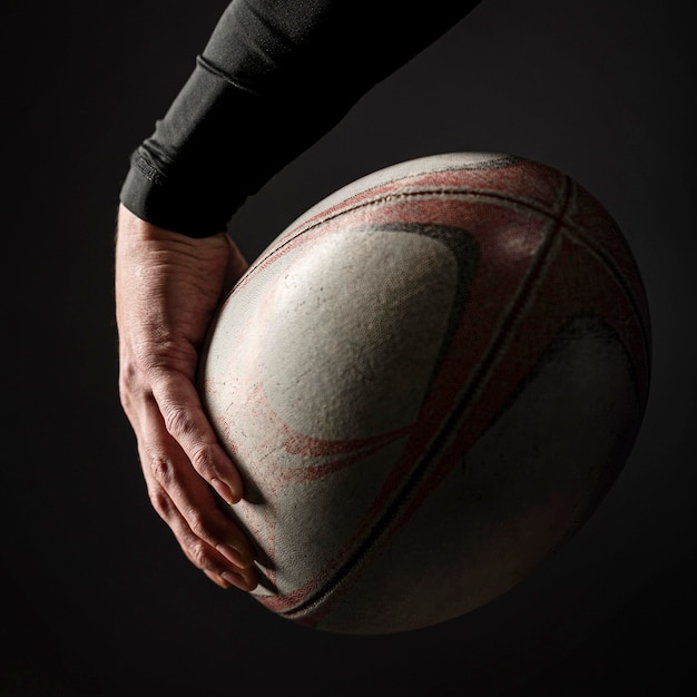 Foto jugador de rugby masculino mano sujetando la bola