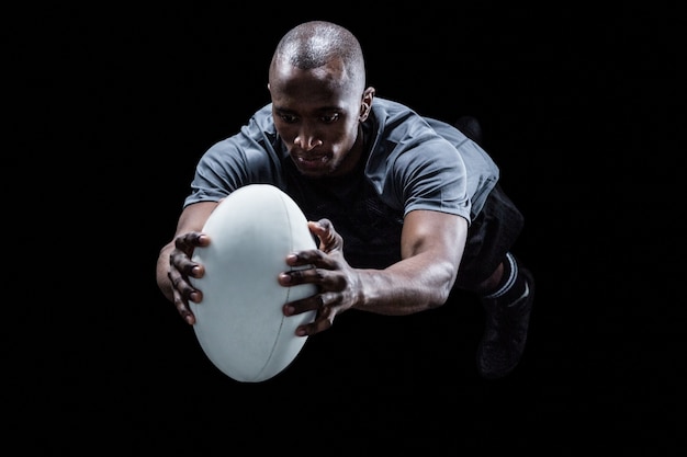 Jugador de rugby saltando mientras atrapa la pelota