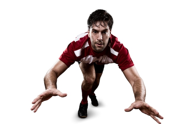 Jugador de rugby con uniforme rojo dando un tackle.