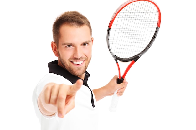 Un jugador de tenis apuntando a la cámara sobre fondo blanco.