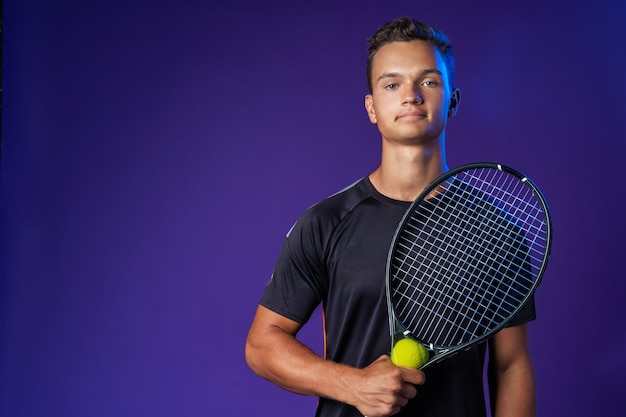 Jugador de tenis caucásico joven posando con raqueta de tenis