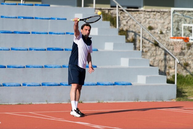 Jugador de tenis caucásico maduro durante un partido en un día soleado