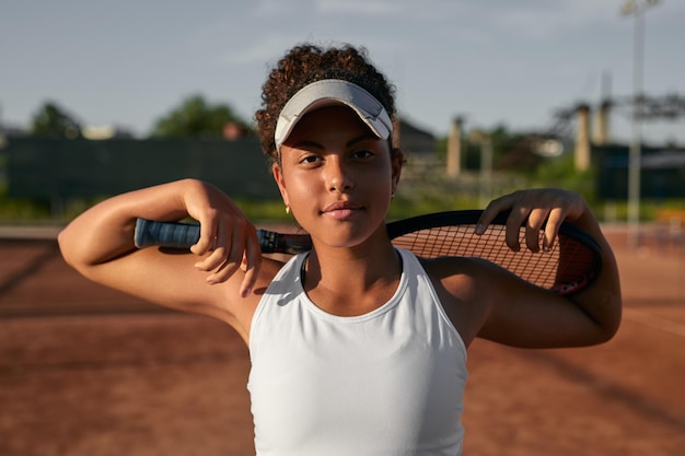 Jugador de tenis femenino negro con raqueta en la cancha