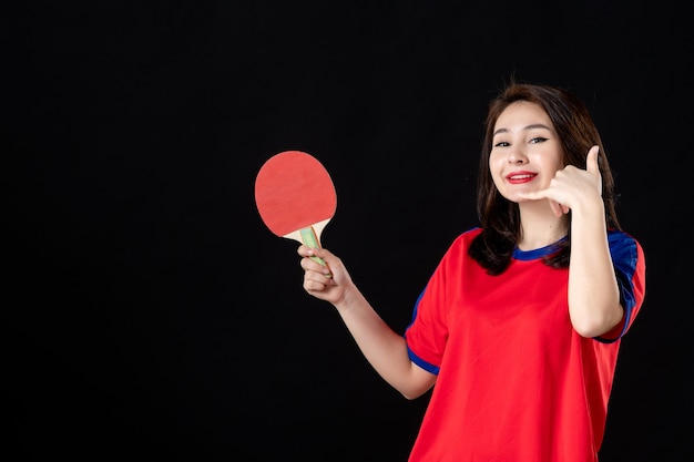 Jugador de tenis femenino con raqueta en la oscuridad