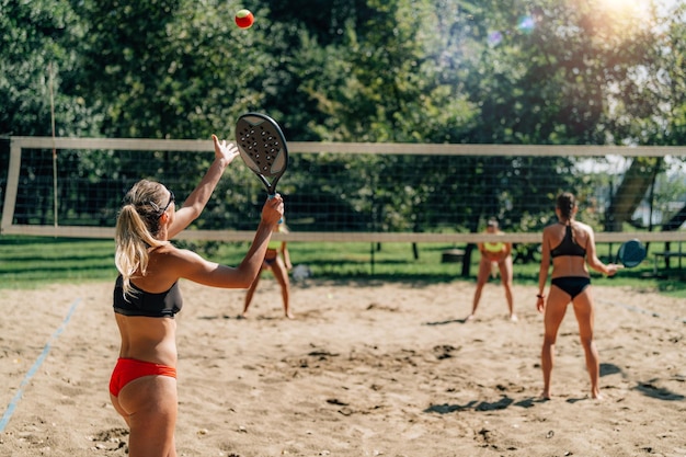 Jugador de tenis de playa sirviendo la pelota