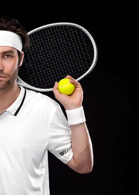 Jugador de tenis con raqueta hombre atleta jugando aislado sobre fondo negro