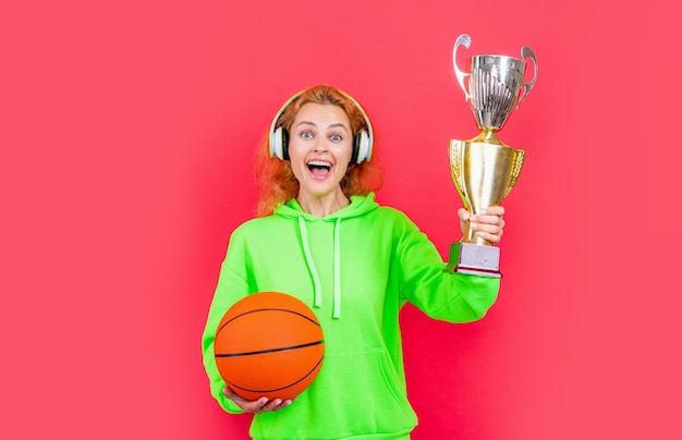 Jugadora de baloncesto campeona en foto de estudio de jugadora de baloncesto con copa campeona