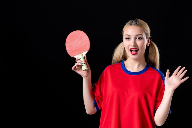 Jugadora con raqueta de tenis de mesa sobre el fondo negro juego de atleta juego deportivo