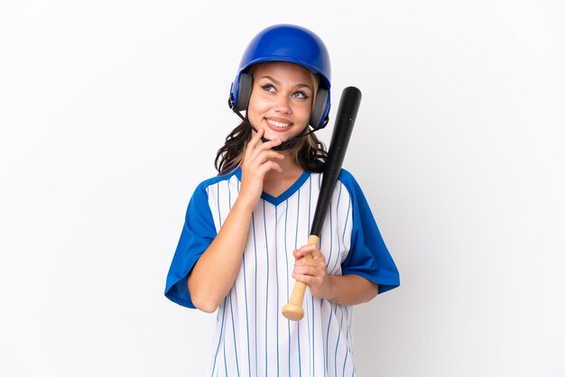 Jugadora rusa de béisbol con casco y bate aislado de fondo blanco mirando hacia arriba mientras sonríe