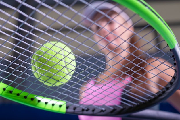 Jugadora sosteniendo una raqueta de tenis y pelota