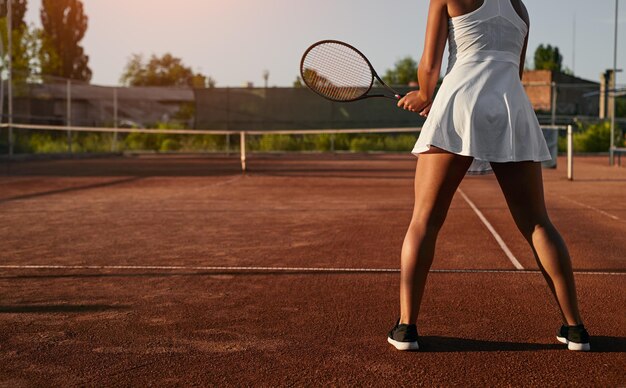 Jugadora de tenis irreconocible entrenando en la cancha