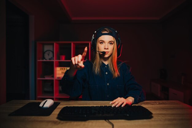 Foto una jugadora toca la pantalla una chica linda con gorra de ropa informal y auriculares juega juegos en línea