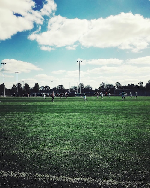 Foto jugadores jugando en el campo de fútbol contra el cielo