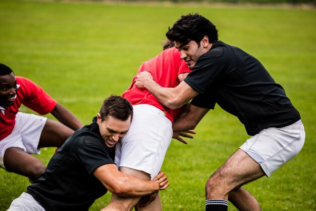 Jugadores de rugby que abordan durante el juego