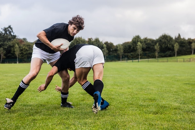 Jugadores de rugby que abordan durante el juego