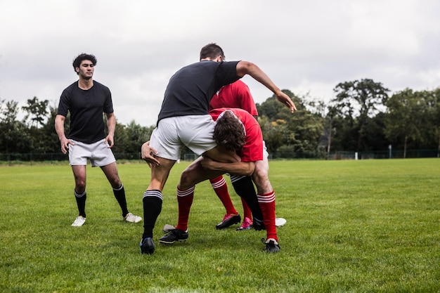 Jugadores de rugby que abordan durante el juego