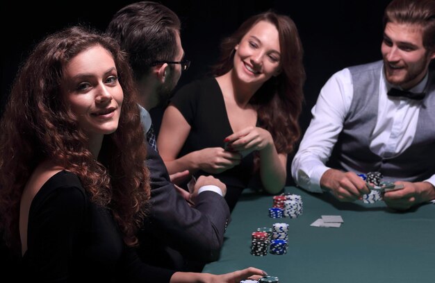 Jugadores sentados en la mesa de juego en el casino.