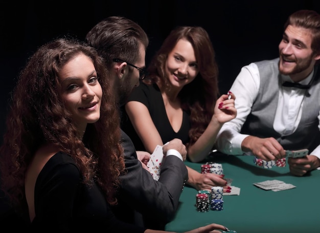 Jugadores sentados en la mesa de juego en el casino.