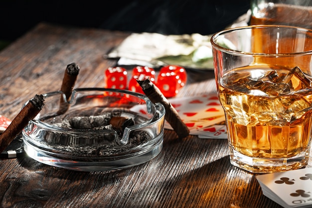 Jugando al póquer con whisky y puros en la mesa