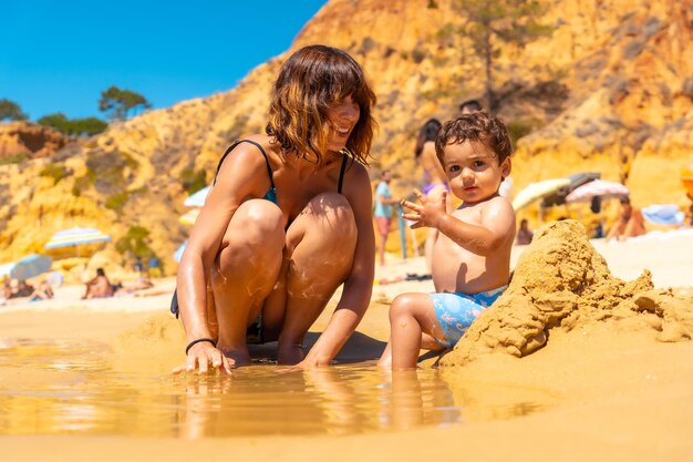 Jugando en la arena con el hijo Praia do Barranco das Belharucas beach Albufeira Algarve Portugal