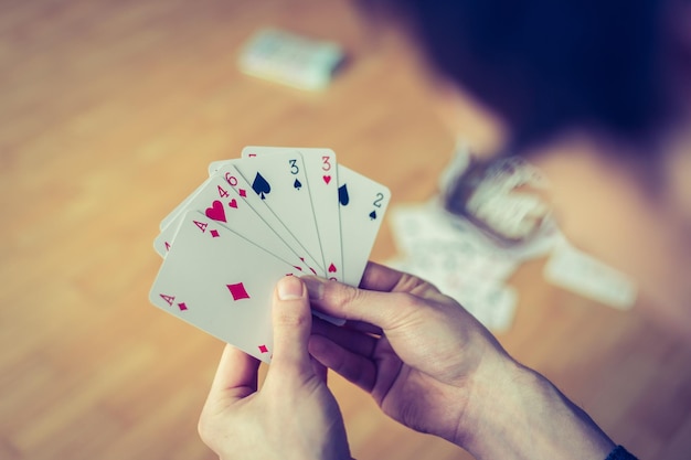 Foto jugando a las cartas cartas de póquer en la mano de un joven